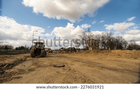 Major construction of road infrastructure . Under the blue sky with clouds. A thoroughly dug up street. Large construction works in the road industry. Visible, excavators, tractors, trucks, cranes etc