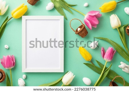 Easter celebration concept. Top view photo of empty photo frame tiny wicker baskets ceramic easter bunny quail eggs and colorful tulips on isolated teal background with copyspace