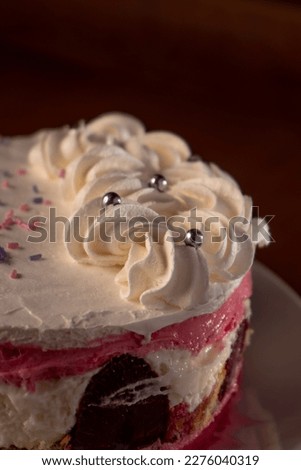 Raspberry cake decoraed fresh berries on cake stand, white table.