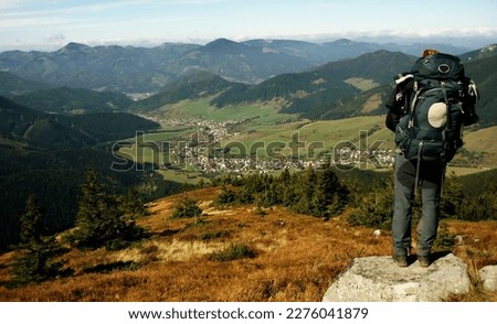 Inspiring photo of a male hiker with a backpack, gazing out into the scenic valley of Low Tatras in Slovakia, embodying the spirit of adventure, exploration, and appreciation for the natural world