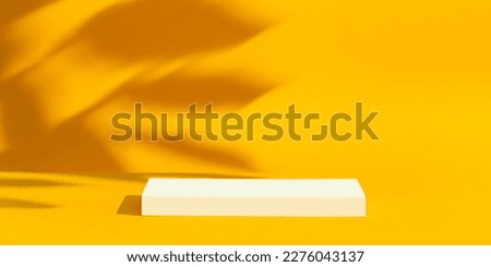 White empty platform, podium on yellow background and tree shadows. Royalty-Free Stock Photo #2276043137