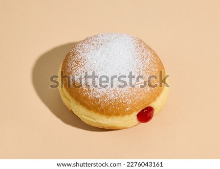 freshly baked jelly donut on beige color background