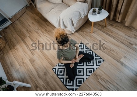 one woman adult caucasian female millennial practice meditation mindfulness yoga with eyes closed on the floor at home real people self care inner balance concept copy space