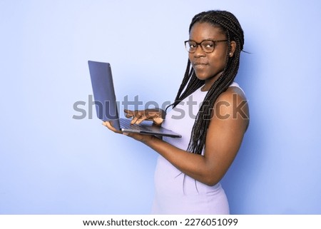 Attractive young African American woman using her high-tech electronic device to help her in education isolated on light purple background