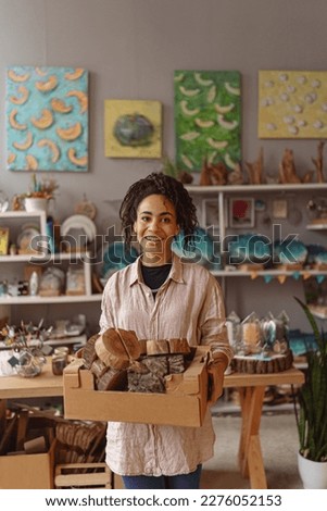 Smiling Woman working in home decor studio with elements of interior decorations