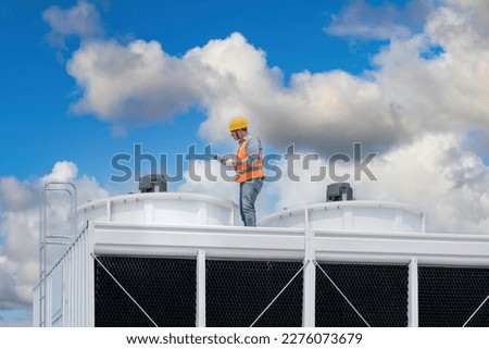 Industry engineer under checking the industry cooling tower air conditioner is water cooling tower air chiller HVAC of large industrial building to control air system. Royalty-Free Stock Photo #2276073679