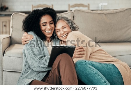 Tablet, daughter hug and happy senior mother with digital photo album, bonding and enjoy quality time together at home. Living room floor, memory and biracial family, people or mom and girl embrace