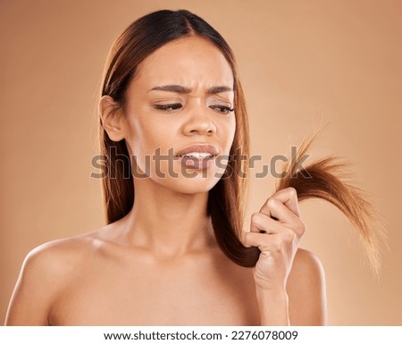 Hair care, frustrated and a woman looking at split ends isolated on a studio background. Unhappy, frizzy and a girl with a problem with damaged, tangled and breakage of a hairstyle on a backdrop Royalty-Free Stock Photo #2276078009