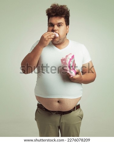 My dietician said I needed to eat lighter foods. an overweight man shoving marshmallows into his mouth. Royalty-Free Stock Photo #2276078209