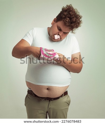 Cant get enough marshmallows. an overweight man with marshmallows shoved in his mouth. Royalty-Free Stock Photo #2276078483