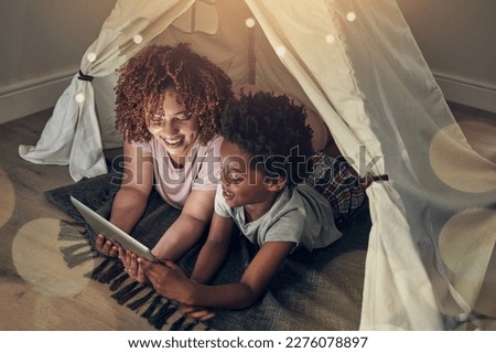 Black family, tablet and mother with kid in tent at night watching movie, video and having fun in home. Technology, bokeh and smile of happy African mom bonding with boy child while streaming film