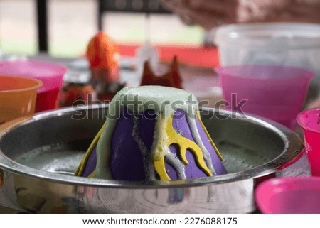 Easter Egg dying volcano using colored baking soda and pouring vinegar into the volcano.
