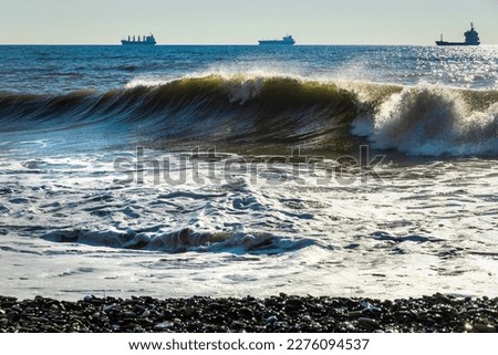 A soft sea wave on a sandy beach. Coastal waves. Selective focus. View of the waves of the Black Sea. Clear wavy sea water. Close-up of a wave on the Black Sea coast.