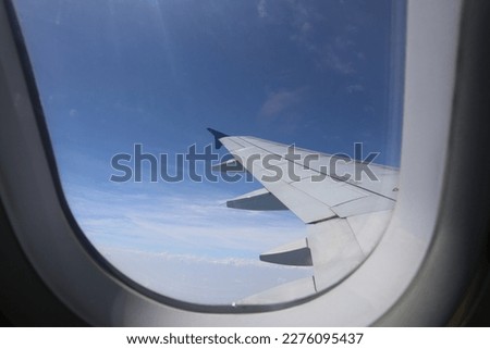 airplane window picture sky white clouds sunlight