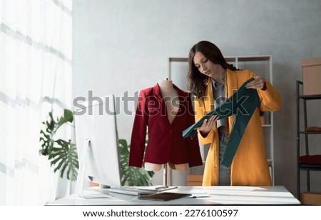 Portrait of young beautiful asian woman fashion designer stylish stand and working with color samples.Attractive young asian girl working with colorful fabrics at fashion studio