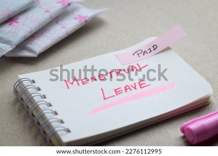 Paid Menstrual Leave handwritten text with sanitary pads. Selective focus on the text.  Royalty-Free Stock Photo #2276112995