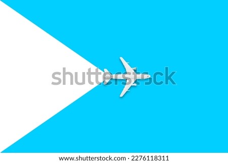 Flat lay of miniature toy airplane on white and yellow background. Travel items on a blue background. Travel and Tourism Concept.
