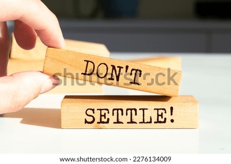 Wooden blocks with words 'Don't settle'. Royalty-Free Stock Photo #2276134009