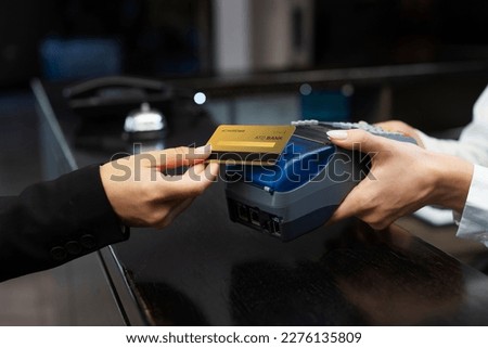Customer using credit card for payment to receptionist. cashless technology and credit card payment concept. customer paying with contactless credit card. NFC technology. credit card reader machine. Royalty-Free Stock Photo #2276135809