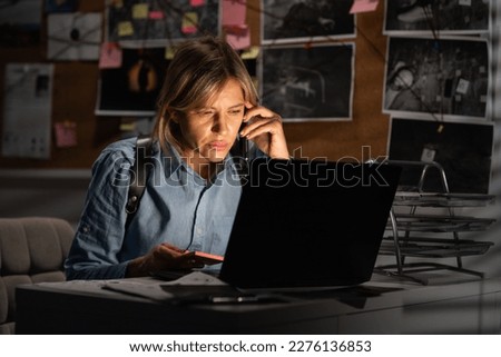 Woman looking at laptop screen in police office calling to colleague. Detective analyzing data and discussing criminal case in agency office. Copy space
