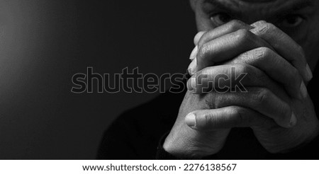 praying to god with religious Caribbean man praying on black background with people stock photo