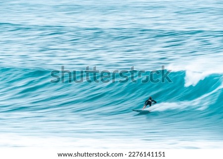 Action motion blur of a surfer riding a wave.