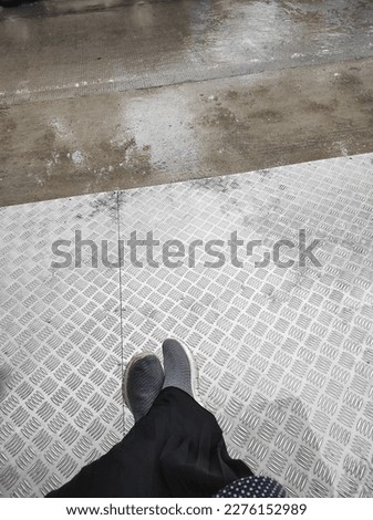 Photo of the feet of a woman sitting at the BRT bus stop in the Karangawen area - Central Java waiting for the bus to arrive Royalty-Free Stock Photo #2276152989
