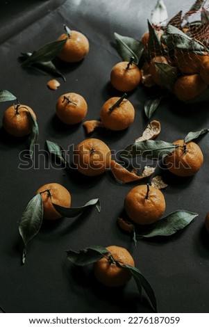 taking picture of orange fruit with black background and playing light and shadow