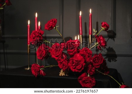 Luxury candlelight dinner setup for couple on Valentine's day. Romantic date. Setting table in restaurant. Location decoration red flowers, decor candles for surprise marriage proposal. Closeup detail