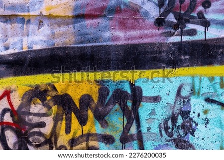Closeup of colorful teal, yellow, black urban wall texture. Modern pattern for wallpaper design. Creative modern urban city background for advertising mockups. Grunge messy street style background Royalty-Free Stock Photo #2276200035