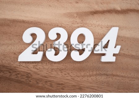 White number 2394 on a brown and light brown wooden background.