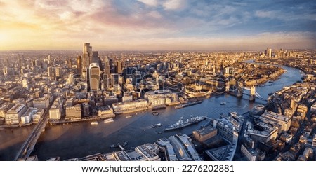 Panoramic sunset view over the skyline of the City of London, England, down the River Thames with Tower Bridge and Canary Wharf district Royalty-Free Stock Photo #2276202881