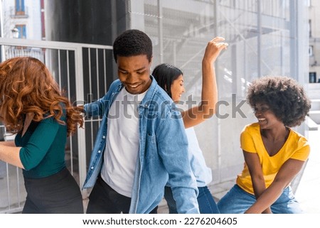 Multiethnic young friends dancing in the city, group of happy people having fun together
