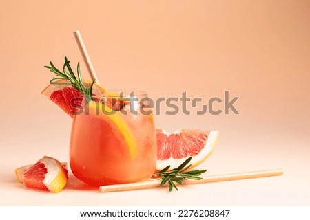 Summer cocktail with grapefruit, rosemary, and ice in a frozen glass. Copy space.