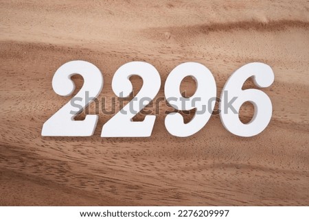 White number 2296 on a brown and light brown wooden background.