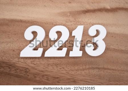 White number 2213 on a brown and light brown wooden background.