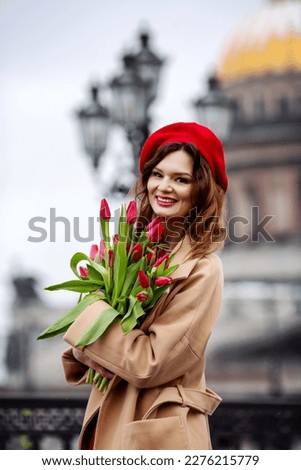 Portrait of a beautiful girl with a large bouquet of flowers on the background of St. Isaac's Cathedral. Happy girl with flowers on a spring day
