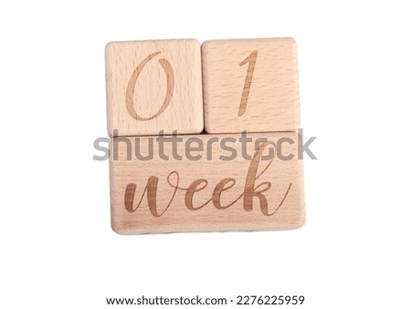 A wooden block showing the date of birth of a newborn child on a white background.