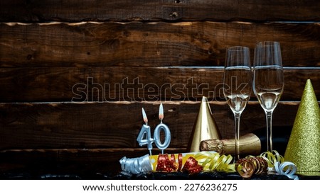 Solemn background for the anniversary with the number 40 . Happy birthday background on brown wooden background with champagne bottle and champagne glasses. Beautiful holiday decorations copy space.