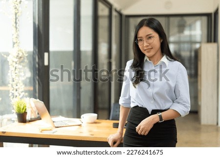 Beautiful Businesswoman standing with her arms crossed and confidently looking at the camera in the office.