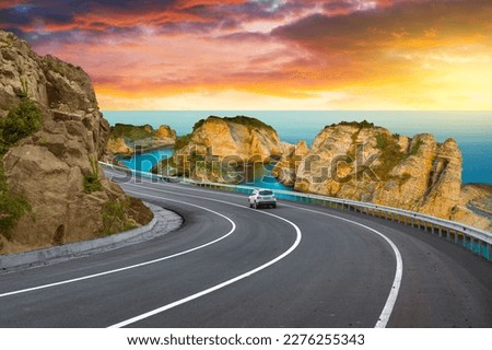 highway landscape at colorful sunset. road view on mediterranean coast of spain. coastal road landscape beautiful nature scenery. car driving on mountain road by the sea. summer vacation on the beach. Royalty-Free Stock Photo #2276255343