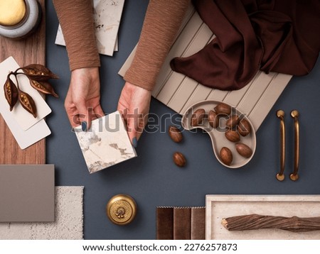 Stylish flat lay composition in navy, brown and beige color palette with textile and paint samples, lamella panels and tiles. Architect and interior designer moodboard. Top view. Copy space. 