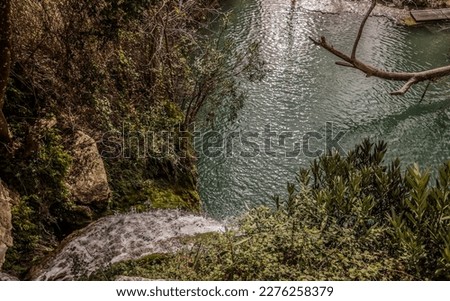 Top View of the Foamy White Water Flowing Down the Adonis Waterfall into a Natural Azure Bath Surrounded by Green Thickets in the Mountains (Koili, Paphos District, Cyprus) Royalty-Free Stock Photo #2276258379