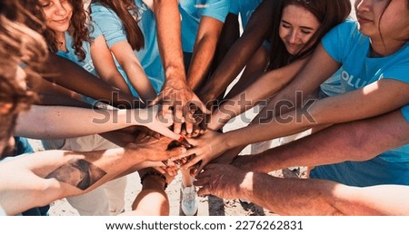 People of different ages and races are united to protect environment from pollution. Happy volunteers stacking hands together to cheer and boost team spirit. Friendship, teamwork, volunteering. Royalty-Free Stock Photo #2276262831