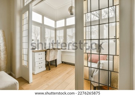 a living room with wood flooring and white shutters on the windows looking out onto an area with wooden floors Royalty-Free Stock Photo #2276265875