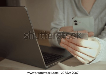 Woman hands holding plastic credit card and using laptop. Online shopping or payment concept. Toned picture. High quality photo