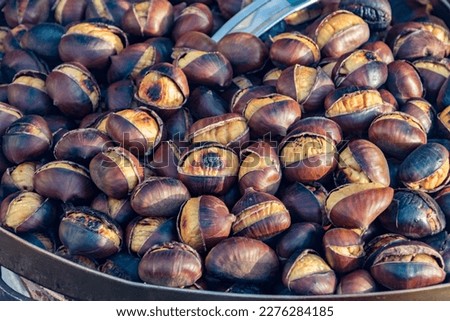 Eat roasted chestnuts. Roasted chestnuts for sale. Royalty-Free Stock Photo #2276284185
