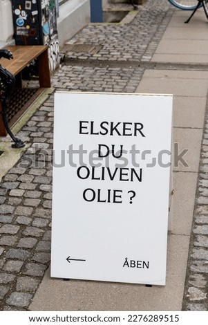 Copenhagen, Denmark A sidewalk sign in the trendy Norrebo district on Jægersborggade asks "Do you like olive oil?" in Danish.
