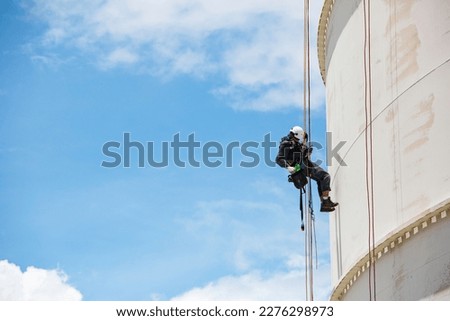 Male worker down height tank roof rope access safety inspection thickness weld of storage tank gas propane. Royalty-Free Stock Photo #2276298973