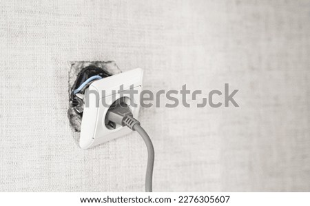 Dangerous bad,broken socket,plug in bathroom,falling out of wall. Outlet installation in old apartment. Poor electrical wire,repair.Terrible do-it-yourself repairmen.Short circuit risk,electric shock. Royalty-Free Stock Photo #2276305607